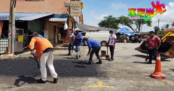 承包商周四（28日）动手为甘榜爪哇早市小贩基地重铺沥青。