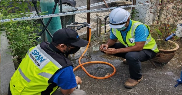 展开执行取缔偷水行动的执法人员当场检视偷水者使用的非法驳接水管器。