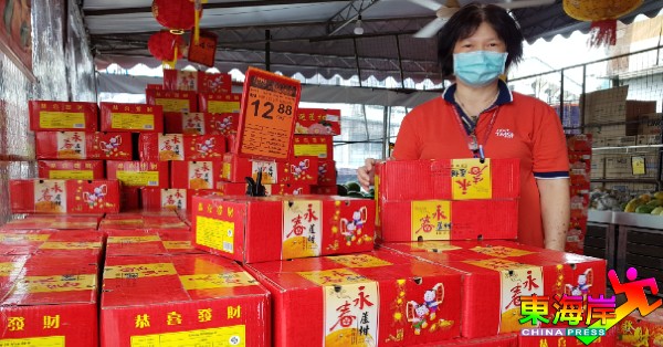 关丹青苗超市（阿亦布爹分行）经理罗异圆展示已上架的正宗永春芦柑。