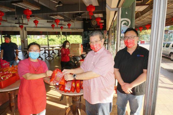 赛夫丁(左2)移交新春福袋给Kemaman Kopitiam茶餐室东主孙爱莲(左)。