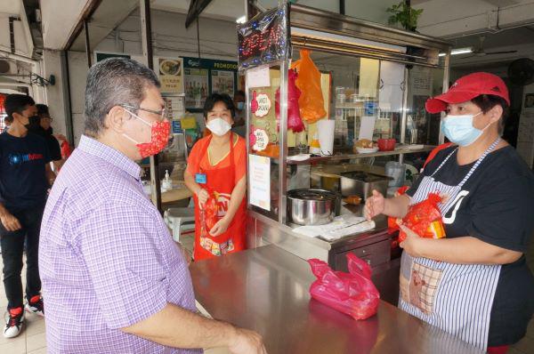 赛夫丁(左)也到关丹阿益布爹饭店,慰问摊主。