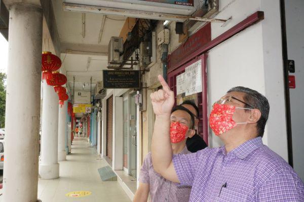 赛夫丁(右)巡视阿益布爹区,店铺门口挂上的大灯笼。