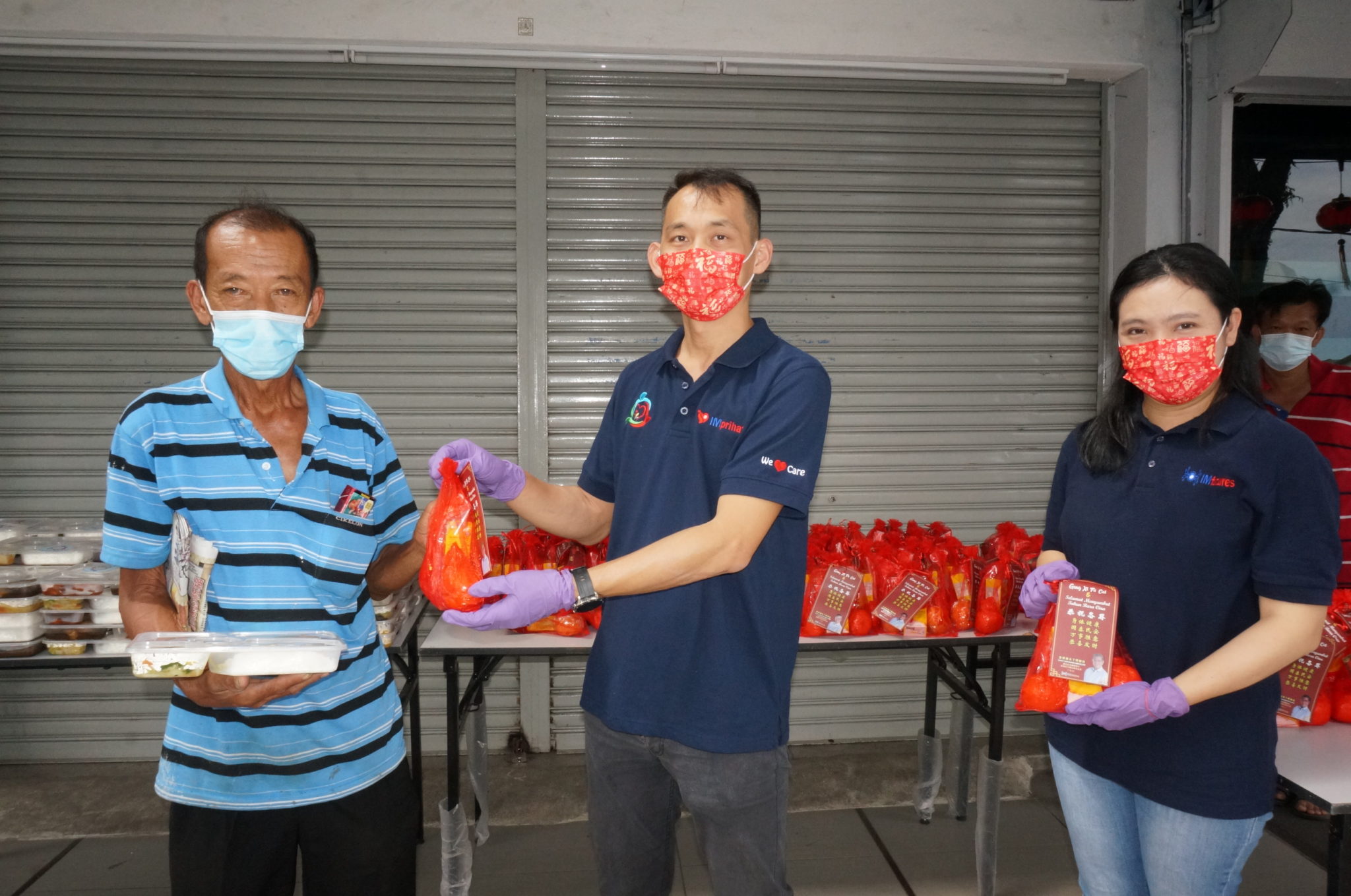 关丹社区关爱服务中心团员廖俊祥(左2)派送年夜饭给长者洪九,右边为郭小庄。