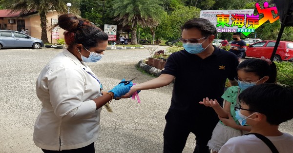 陈祥耀（左2）及家人获关丹县卫生局官员为剪除隔离手环。