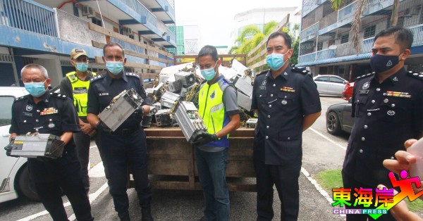莫哈末诺（左2）连同破案警官展示起获的比特币挖矿机零件。