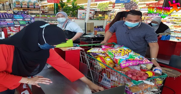 趁周末及落实全国封锁前到超市采购的消费者，以日用品及干粮为多。