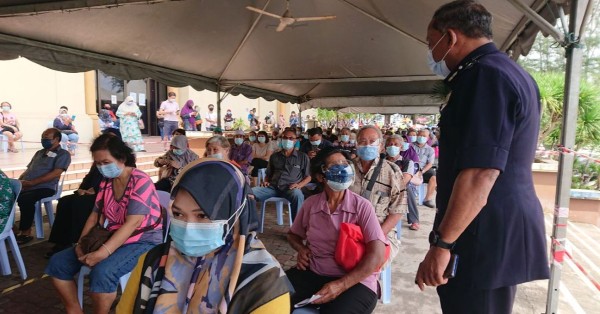 莫哈末诺（右站者）在彭州关丹青年大厦疫苗接种中心巡视，了解民众等待接种情况。