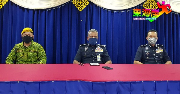 南利（中）向记者发言，左为彭州志愿警卫局主任阿都阿兹及副总警长拿督尤斯利。