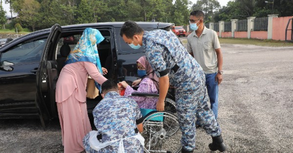 驻守疫苗接种中心的军士们为行动不便居民提供轮椅服务。