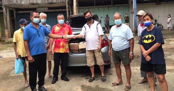 梁永康（左4）率领关丹斗母宫派盒饭义工移交盒饭予覃晓峰，由特伦斯（左2）代表移交。