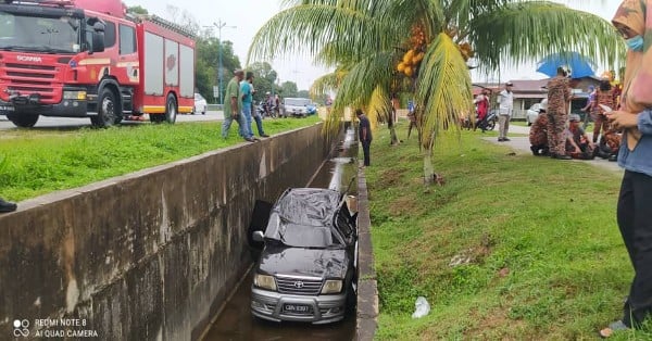 丰田安瑟休旅车不知何故雨中失控后，撞下路旁大排水沟。
