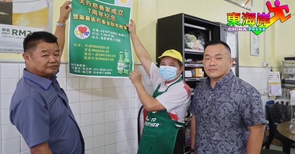蔡永祥（左）获茶室东主冼天生以行动支持，店中张贴筹募医药基金晚宴海报，右为石传伟。