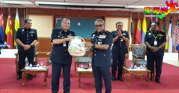 彭州警队防范罪案及社区安全组主任诺希山高级助理警察总监（左）赠送水果礼篮给南利。