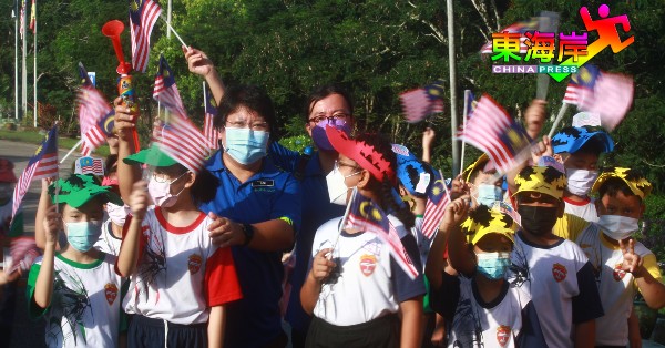 老师、学生及罗素君（左）开心挥舞国旗庆祝国庆月。