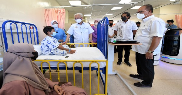 依斯迈沙比里（站者左2）在巡视百乐医院儿童病房设施时，问候病童，右起为彭州大臣拿督斯里旺罗斯迪、卫长凯里。