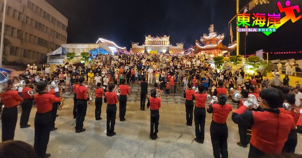 关丹丹那布爹国民型华文中学铜乐队演奏，在宫殿前为九皇大帝宝诞演奏祝寿，吸引香客民众围观。