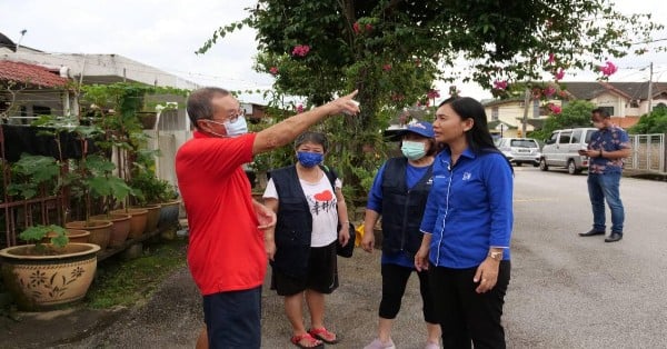 国阵马华德伦敦州席候选人郑春子（右）随同助选团，展开沿户拜票时，聆听居民问题。