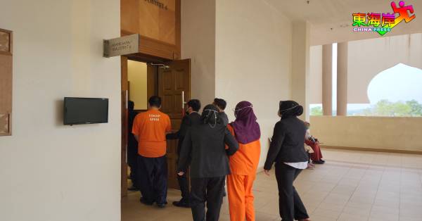 涉嫌合谋虚报茶点费用的男女嫌犯（橙衣者），被彭亨州反贪会官员带往关丹推事庭申请延扣助查。