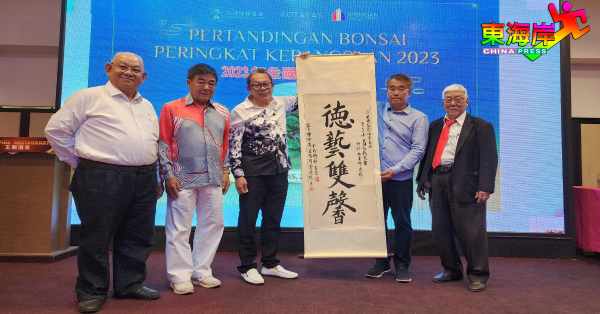 马来西亚盆景艺术创作协会会长曾志明（左3）赠送墨宝予关丹盆栽协会，由署理主席邓作庭（左4）在叶宗文（左起）、贝健康及龙兆宏陪同下接领。