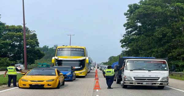 彭州陆路交通局执法人员在繁忙的关丹格宾路段，设路障检查商用车辆。
