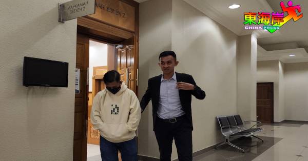 阿末阿米（左）承认收贿罪名后，被反贪会官员带离法庭。