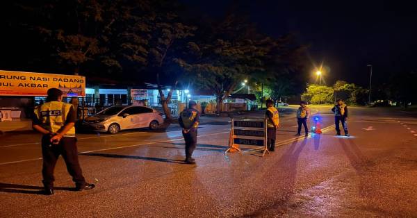 警员凌晨时分守在英迪拉马哥打市镇第14区，进行午夜防范罪案“戳穿”路障行动。