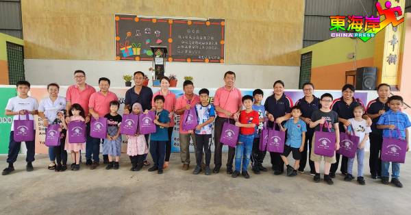 孙诗传（左14）率同董家协成员，为各班级班长代表颁发儿童节恩物。