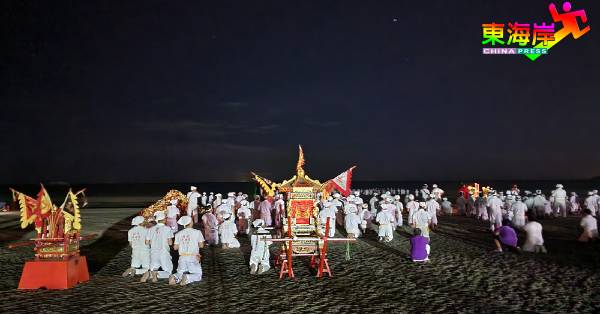 全体白衣裤的理事、炉主头家及义工团成员，一致拈香齐在沙滩上跪送九皇大帝皇驾回銮，形成神圣景观。