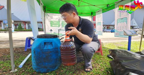 林正杰将居民收集的使用过食油，准备置入特定塑料桶。