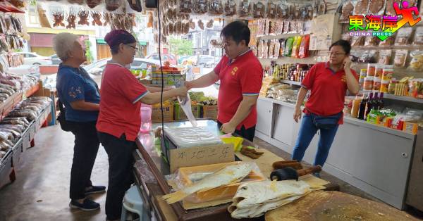 游客趁到关丹一游，采购本地特产梅香咸鱼等海产干货，做为拌手礼。
