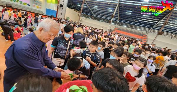 林锦志（左）亲自派送儿童恩物予现场学生。