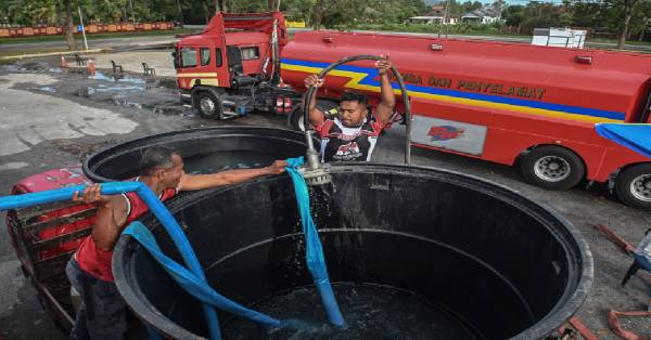 志愿消防员在消防水槽车的协助下，将洁水运送到运点临时水箱供居民取用。