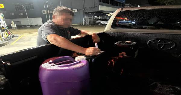 彭亨国内贸易及生活成本局执法人员即场检测油桶内柴油。