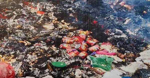 已被纵火焚烧的垃圾中，清晰可见被丢弃的罐头沙丁鱼。