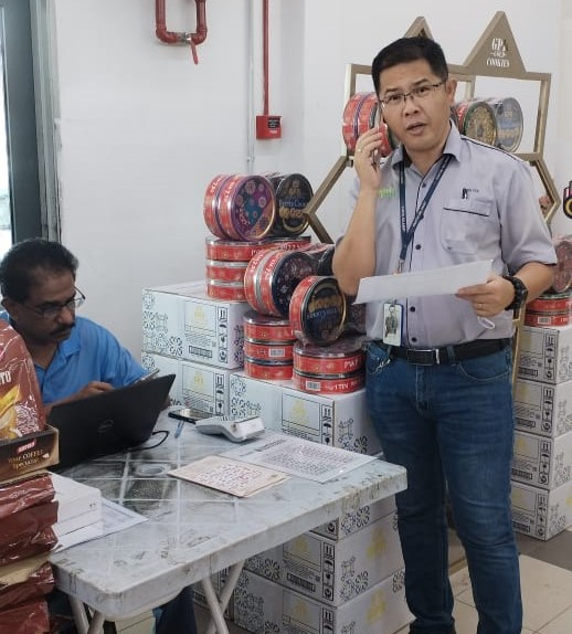 郑彣禧（右）连同临时柜台官员依据MyKasih 100令吉粮食援助购物券名单，逐一拨电联络区内受惠者。