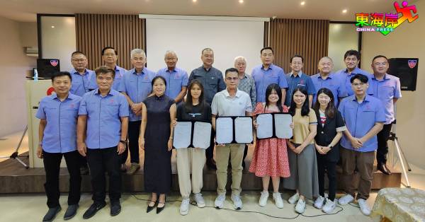 黄崇洸（后排左5）率同关丹中华总商会理事会，见证东钢集团与服务奖学金学生签署合约。