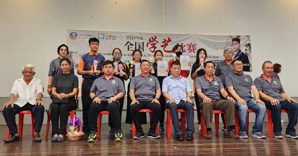 马潮联青学艺比赛关丹区初赛高中组华文硬笔书法赛得奖学生，与大会嘉宾及理事合影。