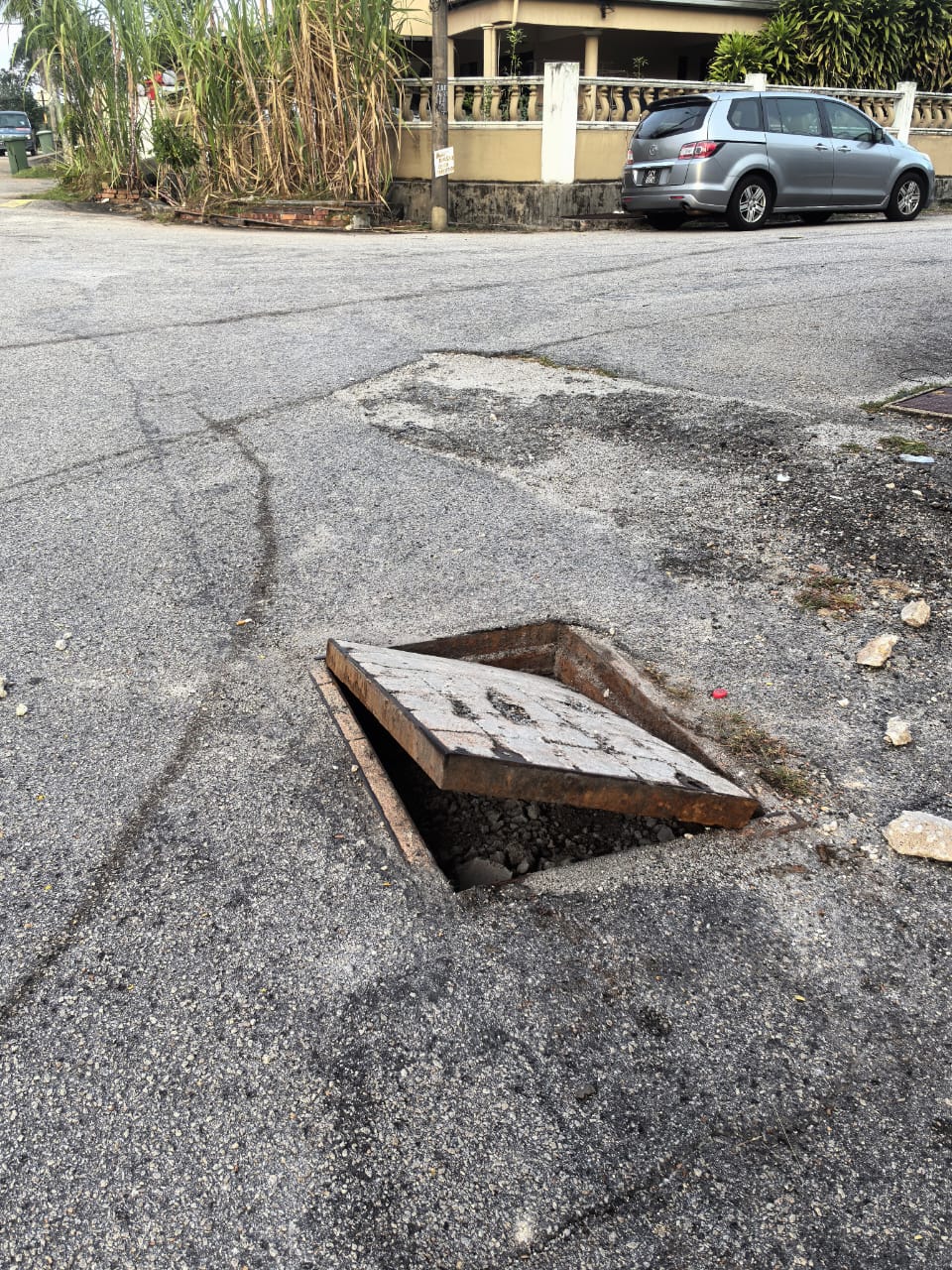 住宅区小巷路口中央出现被撬起井盖，形成危害居民及公路使用者安全“陷阱”。