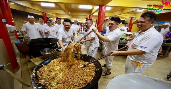 梁永康（右3）率同青年团成员，为素食夜宵大锅炒面。