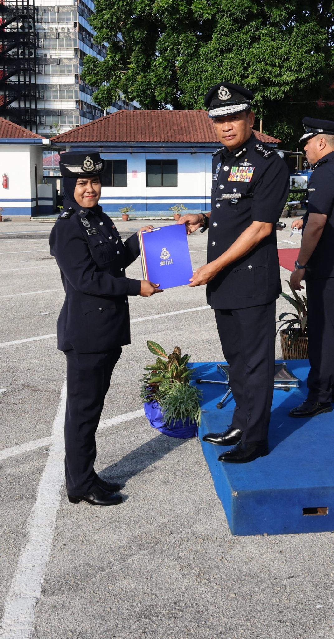 驻关丹商业罪案组女警官再顿莫哈末警长（左）从雅哈亚手中接过卓越服务感谢状。