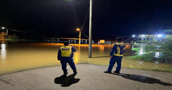 民防部队漏夜巡访因河水泛滥淹没的住宅区域，确保没灾民受困。