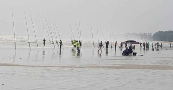 大风浪及下雨天也无阻热钓鱼爱好者，守在海岸边享受垂钓乐趣。