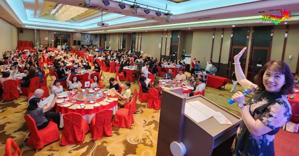 东彭华校教师公会众会员在丘月清(右)主持年度常年会员大会上,举手一致通过大会提案。