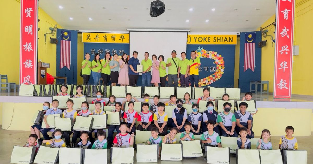邓世坚(后排左6)接领永杰移交书包文具时,与受惠学生一起合影。