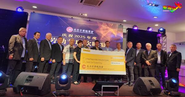 黄崇洸(左5)在众嘉宾、理事陪同下,移交商会捐赠购买精明课室智能一体义款奇予关丹光华华校的模拟支票,由校长颜秀萍。