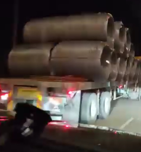 疑是另一辆罗厘违规载钢卷在大道上行驶，甚至连后方木板都没有拉上。