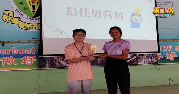 第四组组员叶俊豪（左）获最佳男营员奖，由副营长丘清云颁发奖项。