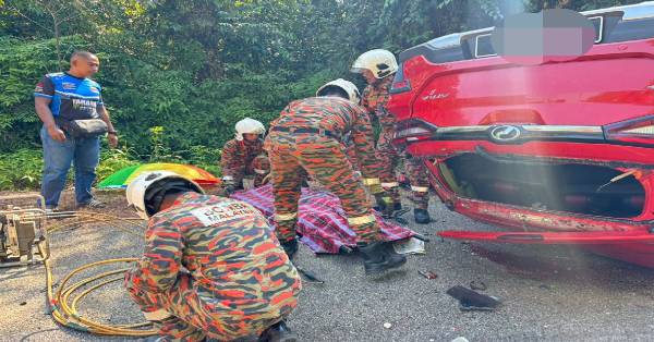 消防员通过器具将夹毙在驾座的男死者遗体移出。