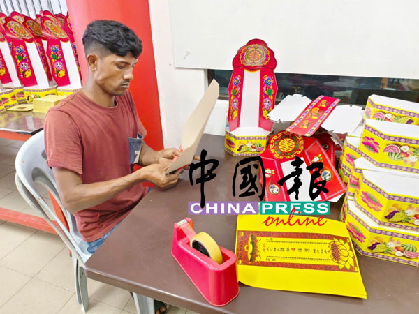 外劳阿当以熟练的手法摺叠灵位牌。