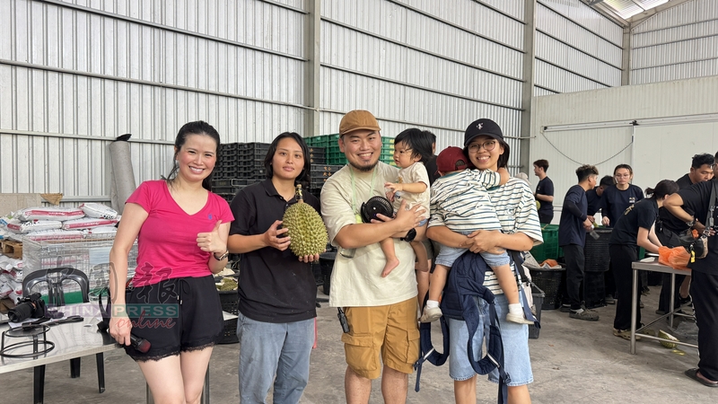 徐馨蔚（左2）颁发3公斤特级猫山王榴梿给抽奖环节的幸运儿，左为张月。